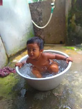 Indian Cute Baby Bathing in a Large Pot Stock Photos