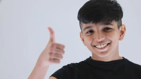 Indian cute boy walking towards the camera and smiling showing thumbs up he Stock Footage 159595644