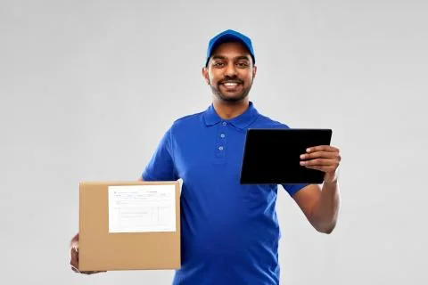Indian delivery man with tablet pc and parcel box 写真素材