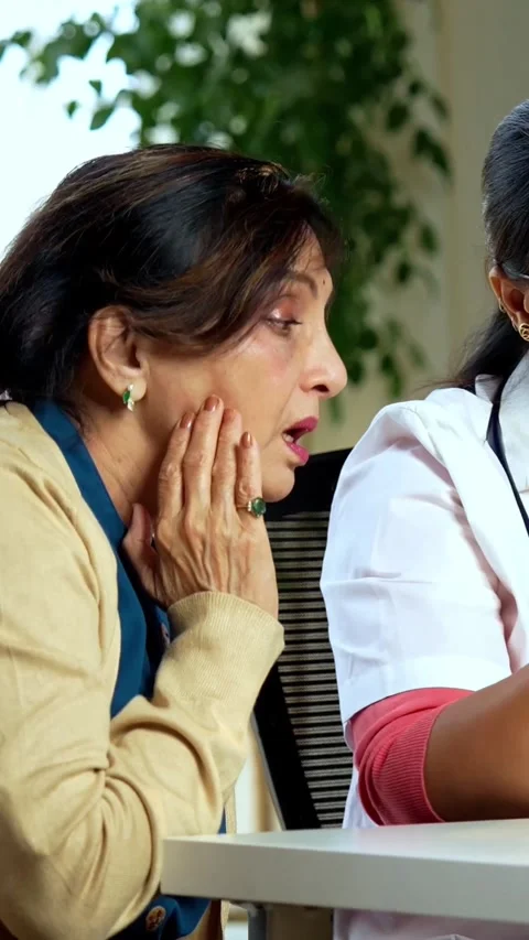 Indian Dentist using a denture model and laptop to explain oral health Stock Footage 342430417