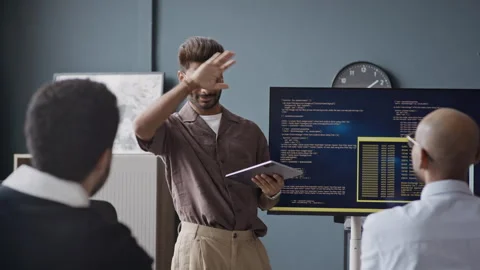 Indian Developer Presenting Code to Colleagues in IT Office Vidéo 337493151