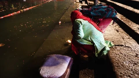 Indian devotee offering oil lamp to holy river ganges at evening from flat .. Stock Footage 278157492
