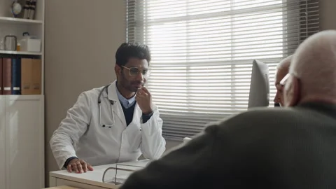 Indian Doctor Discussing Treatment Plan with Senior Couple Stock Footage 339628811