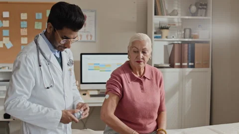 Indian Doctor Explaining Glucose Sensor App to Senior Woman Stock Footage 339629247