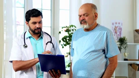 Indian doctor explaining medical case and procedure to senior patient Video stock 342426688