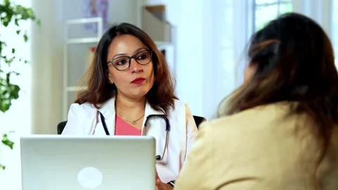 Indian Doctor using laptop to discuss medical case, senior patient in clinic 스톡 동영상 342430789