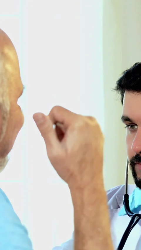Indian Doctor using a stethoscope to examine an elderly patient in OPD Stock Footage 342427328