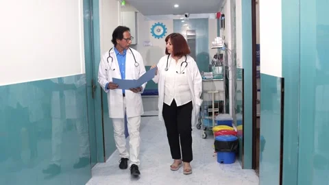 Indian doctors discuss reports documents of patient while walking at hospit.. Stock Footage 278305687