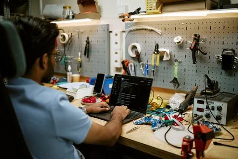Indian Electronics Engineer Coding on Laptop in Hardware Workshop Stock Photos