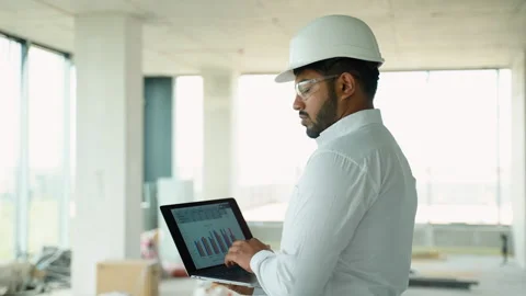 Indian engineer analyzing construction project data on-site using laptop Stock Footage 285670040