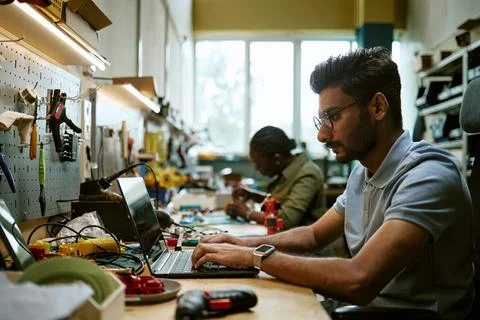 Indian Engineer Coding on Laptop in Hardware Workshop Stock Photos