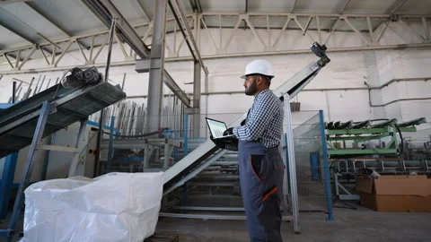 Indian engineer examining document using laptop at windows factory Stock Footage 282999770
