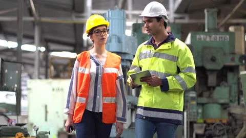 Indian Engineer in Hard Hats and Inspector woman talking and inspect machines Stock Footage 139819975