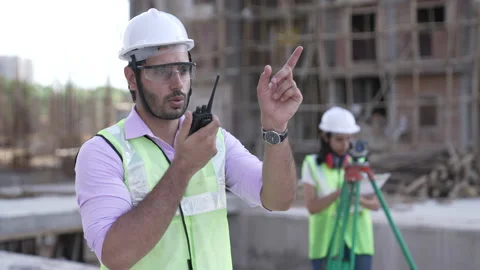 Indian engineer operate with radio talking to control working at construction. Vídeos de archivo 161809919
