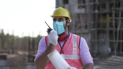 Indian engineer operate with radio talking to control work at construction. Video stock 161814658