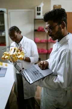 Indian Engineer Programming Robotic Prototype with Laptop in Lab Stock Photos