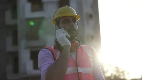 Indian engineer talk on smartphone while hold blue prints at construction. Stock-Footage 161815196
