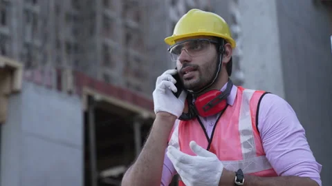Indian engineer talking on smartphone to control working at construction. Video stock 161876494