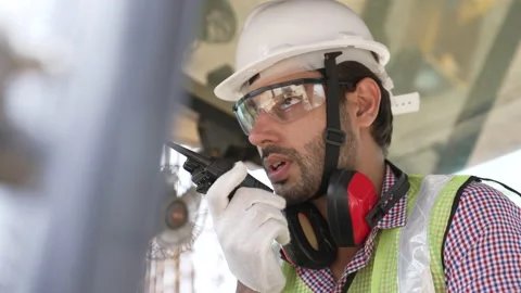 Indian engineer using radio talk to control work on construction site. Video stock 162017834