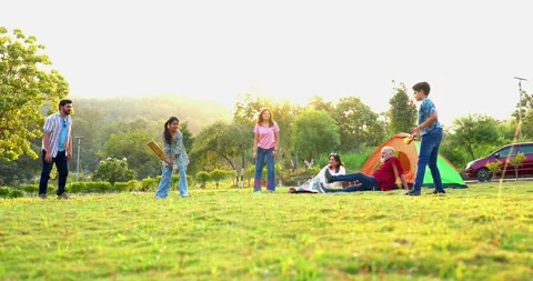 Indian family playing cricket while camping outdoors bonding with laughter Stock Footage 342840738