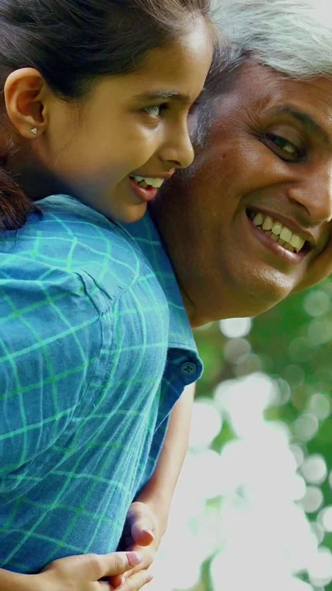 Indian father in his forties joyfully carrying daughter on his back Stock Footage 343364853