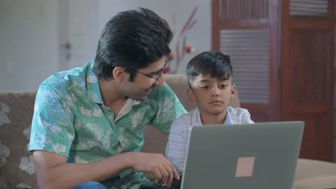 Indian father son spending time together watching educational film on a laptop. Stock Footage 211363152
