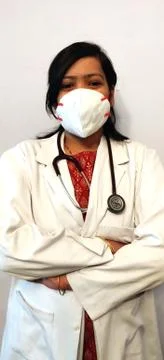 An Indian female doctor in white coat, stethoscope and face mask Stock Photos
