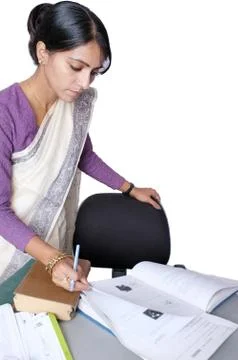 Indian female instructor checking exam sheets. Stock Photos