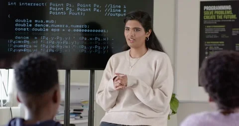 Indian female mentor on stool pointing to code on screen, guiding African 動画素材 341029554