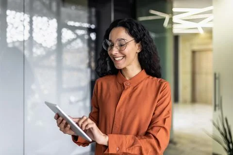 Indian female programmer standing inside the office with a tablet computer in Foto stock