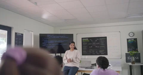 Indian female teacher responding to code on monitor, leading coding lesson and Stock Footage 340811517
