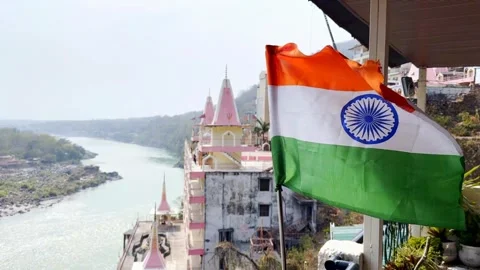 Indian flag waving in slow motion with view of Rishikesh and Ganges river Stock Footage 315876612