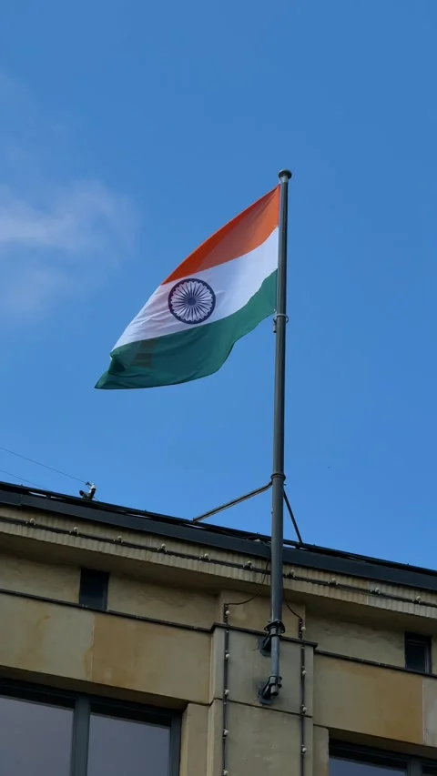 Indian flag waving on tall pole against blue sky with clouds Stock Footage 335579513