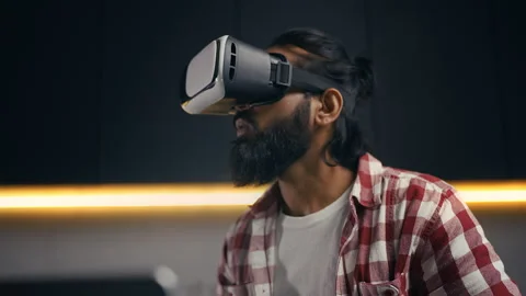 Indian game designer testing VR simulator in headset, game development Stock Footage 313281799