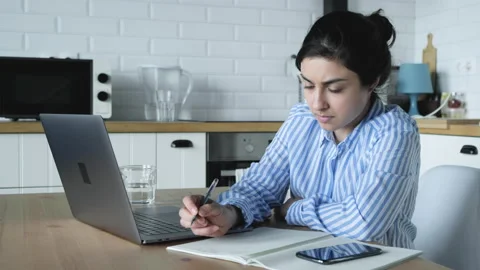 Indian Girl makes Notes in a Notebook and Works on a Computer Stock Footage 134439640