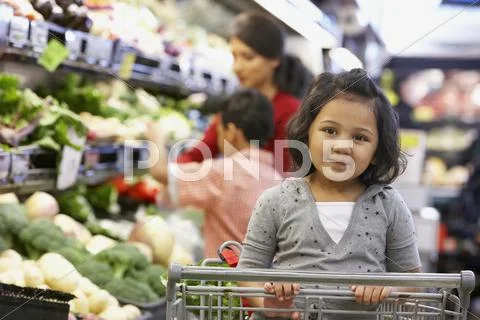 Indian girl sitting in shopping cart Stock Photos