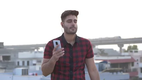 Indian guy dancing while listening audio songs on cell phone using music apps. Видео 148824099