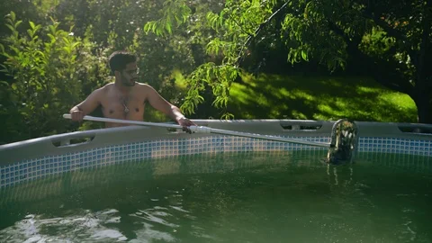 Indian Guy in Glasses Cleans Garbage from Frame Garden in the Garden Stock Footage 113071899