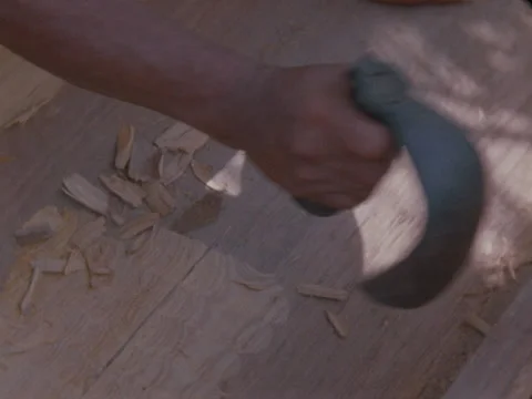 Indian hand cuts chips from log, making a new pirogue in jungle of Panama. Stock Footage 148126430
