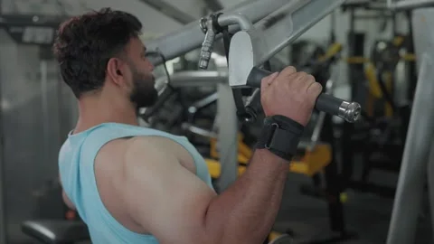 Indian healthy man training his shoulders using machine in a modern gym  Video stock 341856519