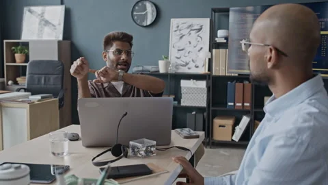 Indian IT Professional Explaining Project to Colleague in Modern Office Stock Footage 337482530