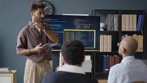 Indian IT Specialist Explaining Code on Screen to Colleagues Stock Footage 337485523