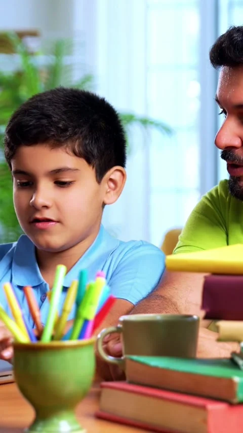 Indian kid studying on laptop while father helping during online education Stock Footage 342758173