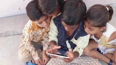 Indian kids sharing a touch screen phone mobile screen, handheld top-shot Vídeo Stock 69871968