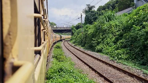An Indian local passenger train or express train crossing under an old brid.. Stock Footage 313381526