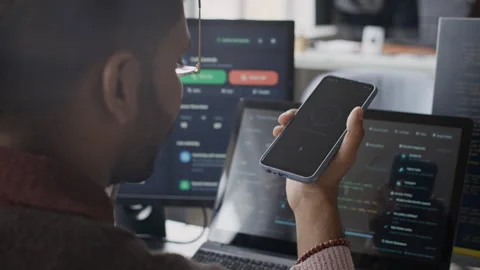 Indian Male Developer Using Smartphone for Security Authentication in Office Stock Footage 337475728