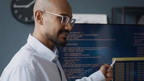 Indian Male Engineer Explaining Code on Screen during IT Presentation in Office Stock Footage 337493514