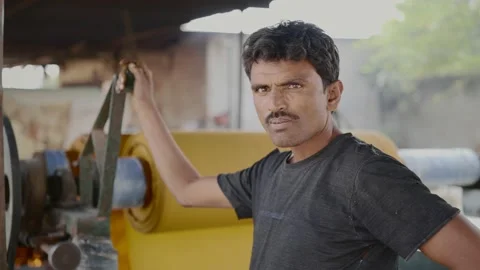 An Indian male local textile factory laborer standing by running the machinery Stock Footage 149302326