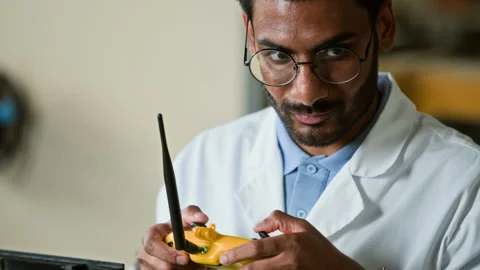 Indian Male Scientist Testing Robotic Device Using Remote Control Stock Footage 343512513