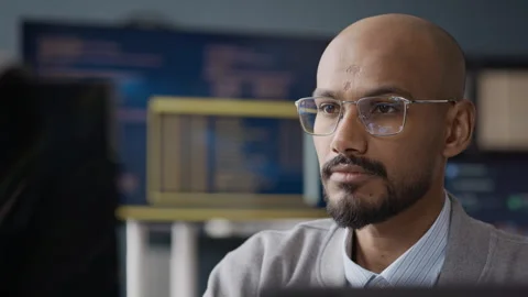 Indian Male Software Engineer Analyzing Code on Computer Screen Vidéo 337474677